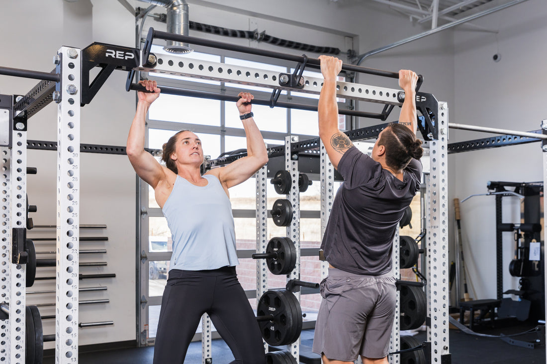 Two athletes do pull-ups.