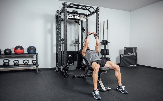 Man doing incline flies on a bench using front trolleys of Ares 2.0